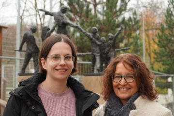 Zwei Frauen lächeln in die Kamera.